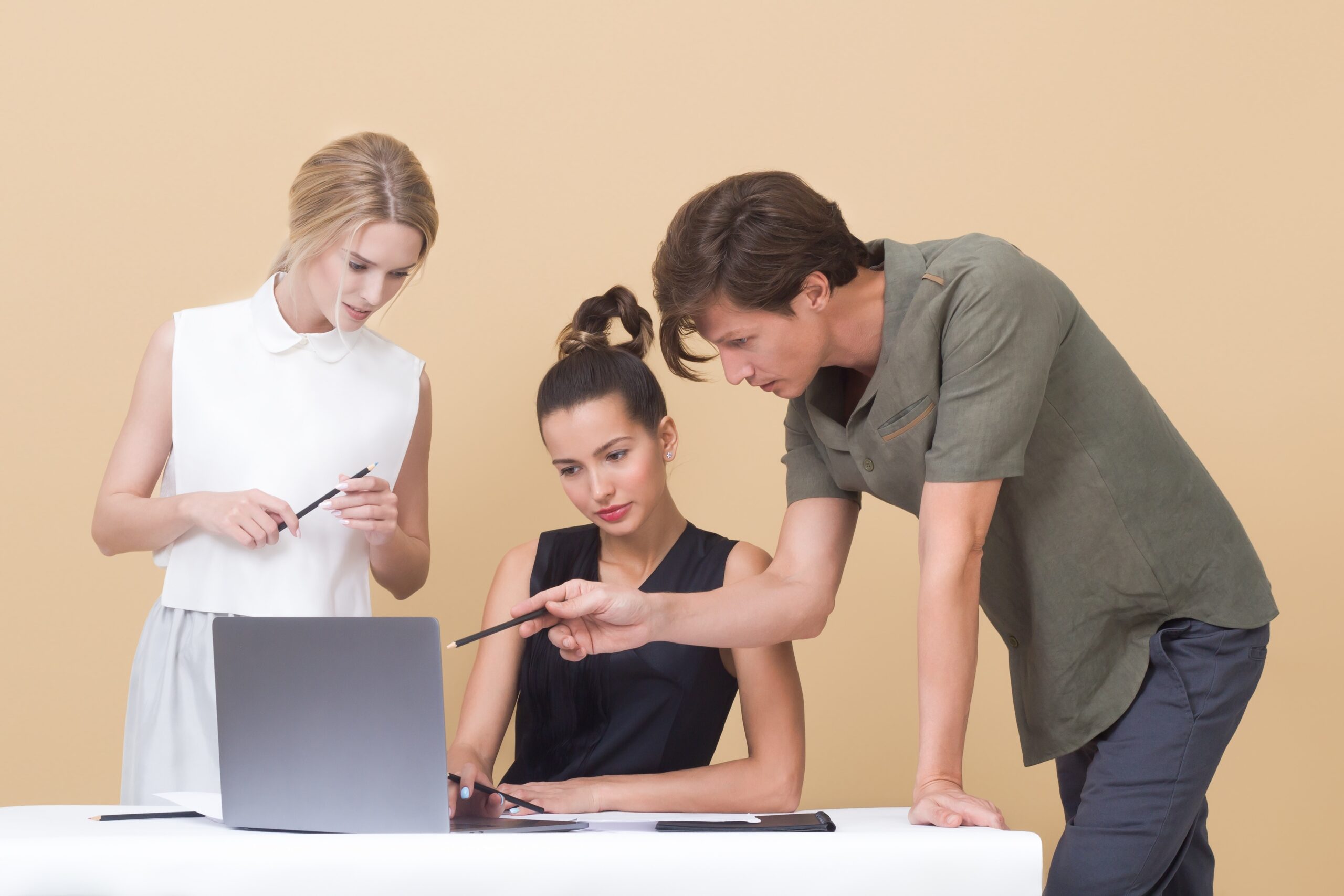 3 employés travaillent en consultant un ordinateur portable