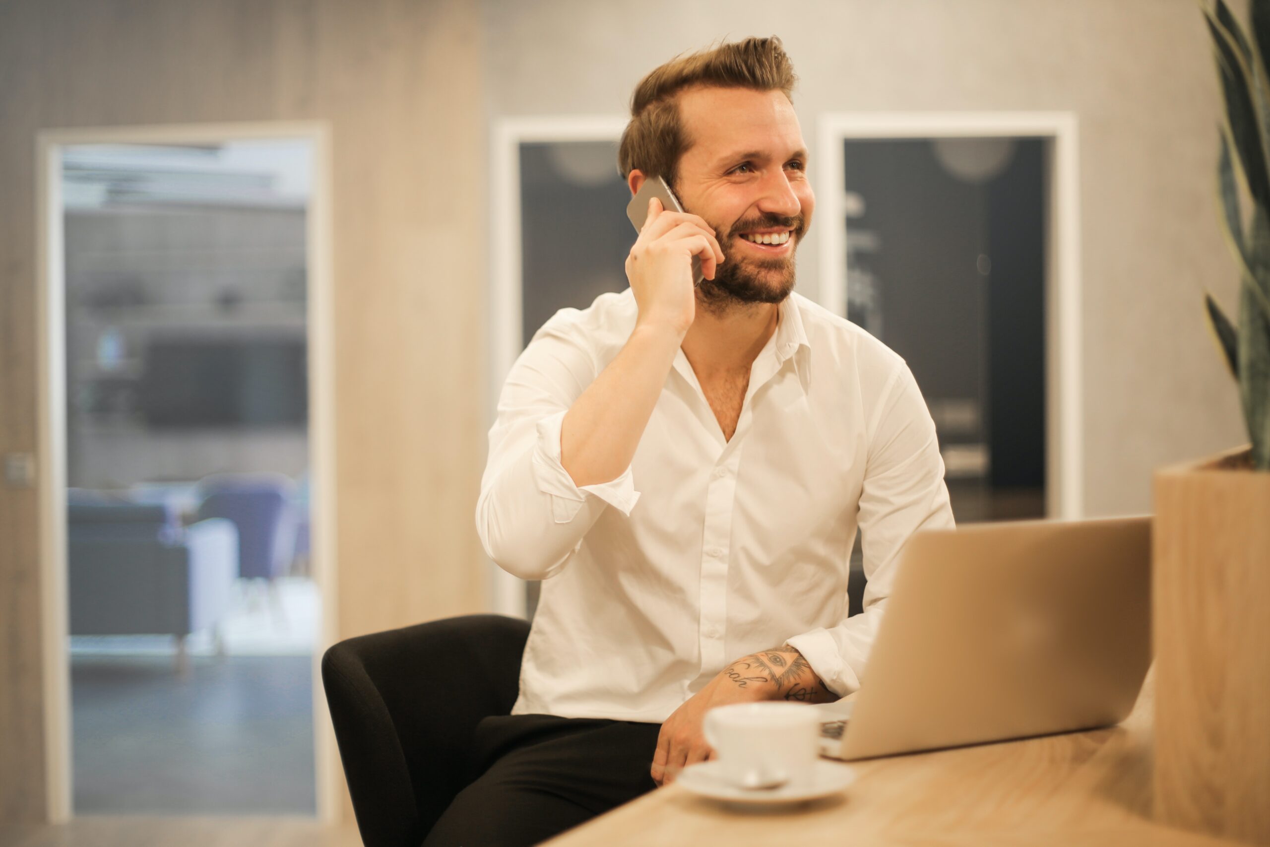 un homme au bureau qui télépĥone
